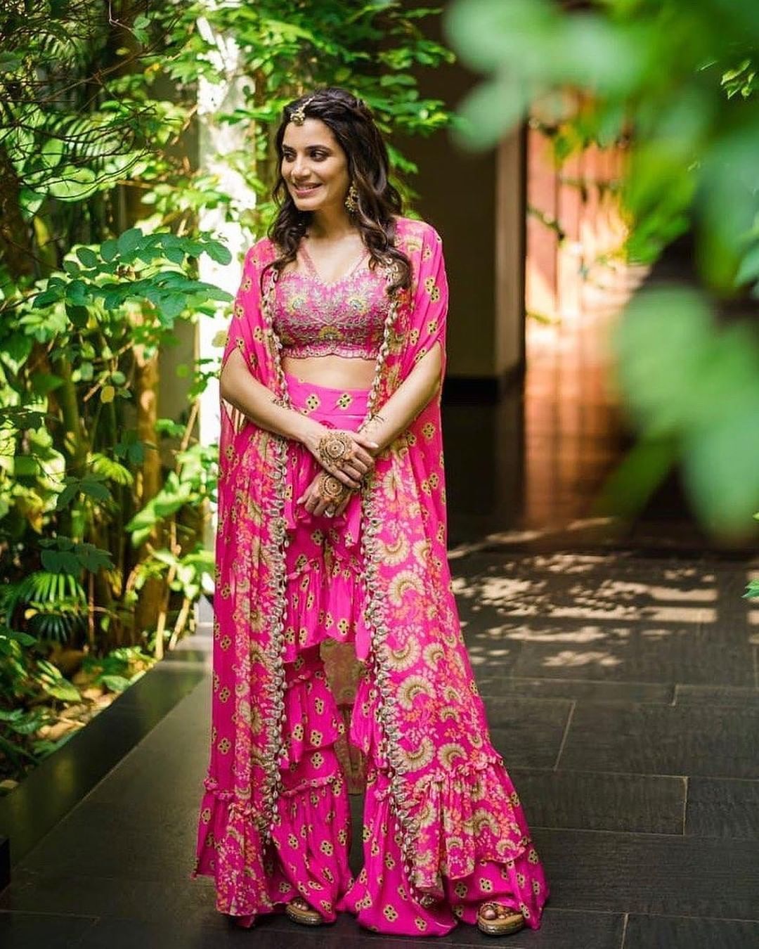 bride wearing a pink cape outfit on mehendi