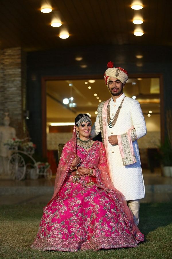 Bride in Pink Lehenga and Groom in Ivory Sherwani, Floral Necklaces, Hold  Coconut at Baraat