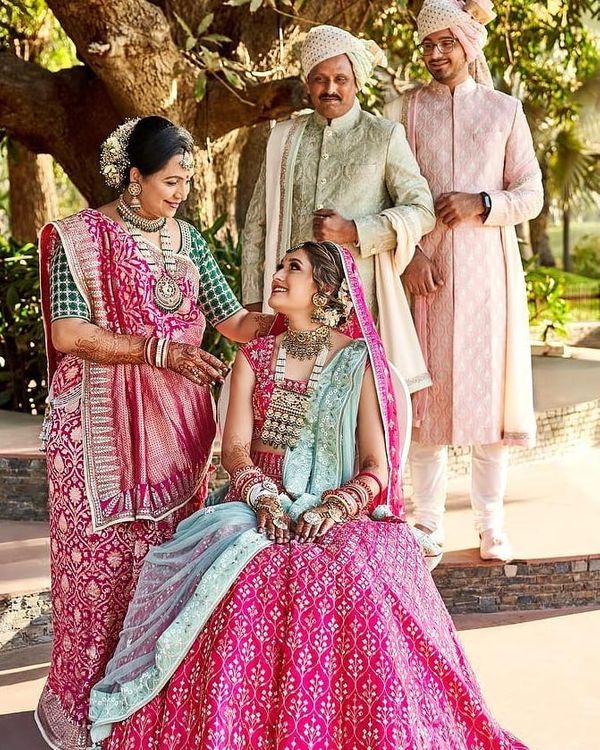 Couple portrait on wedding day with bride in a pink benarasi lehenga and  groom in navy blue sherwani |… | Couple wedding dress, Indian wedding,  Indian wedding gowns