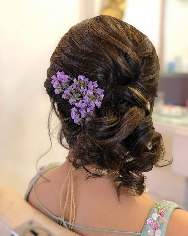 Photo of A twisted bridal bun outlined with white flowers