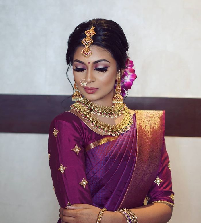 Image of Traditional Indian Female/Woman Model in Purple Saree, green Blouse  with a Lotus flower in hand-AW534724-Picxy