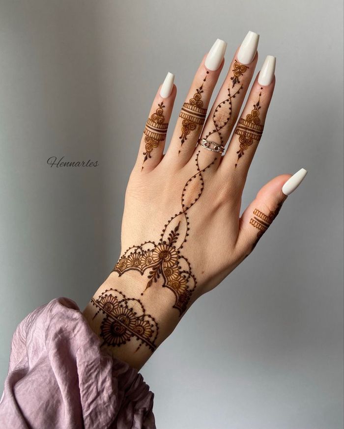 Beautiful female hand with henna tattoo and reed diffuser on grey  background Stock Photo - Alamy