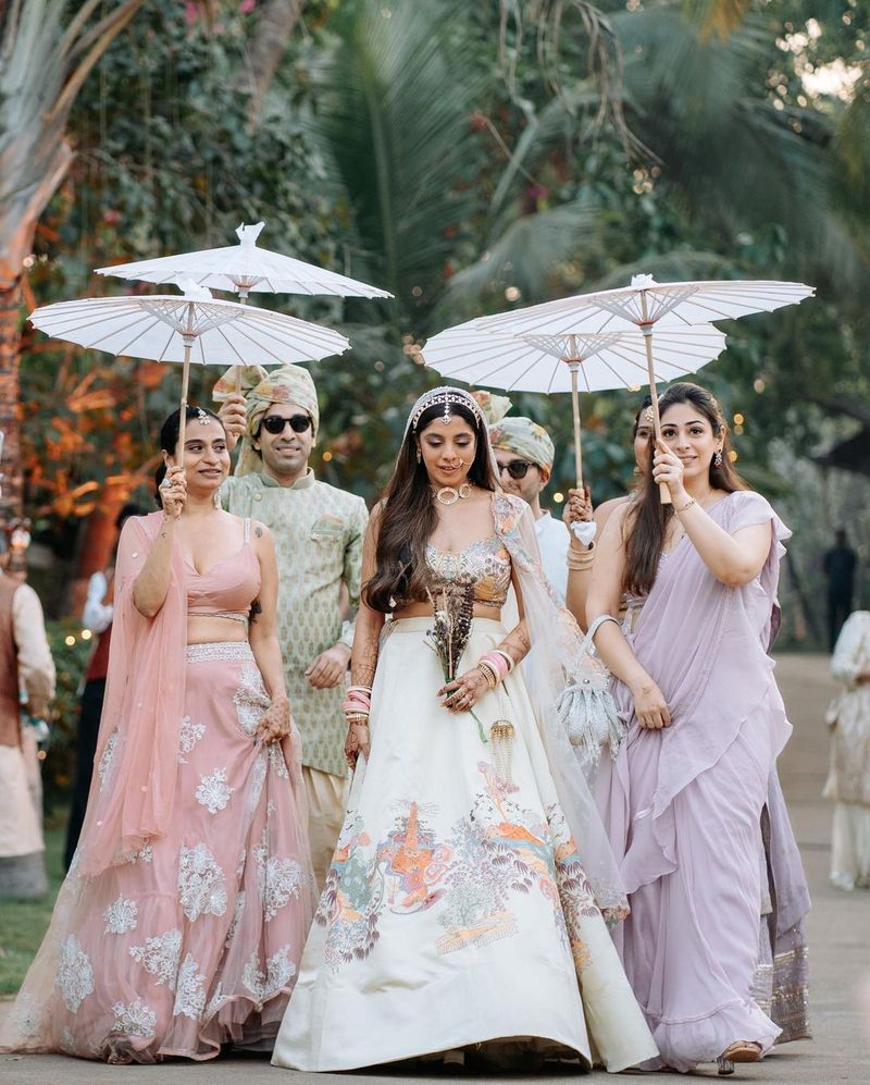 Bride walking under a Japanese parasol during her entry