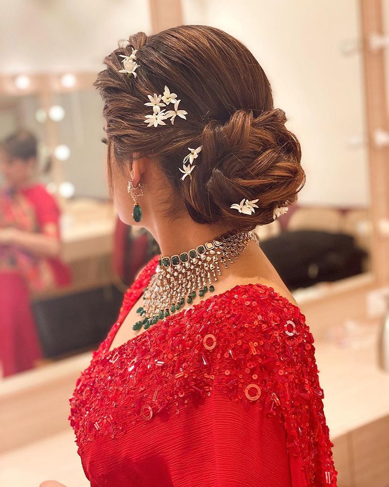 Twisted low bun finished with mogra flowers