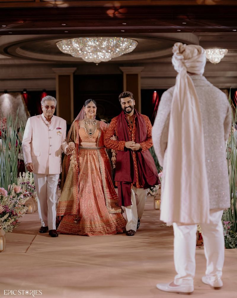 Bride and sibling holding hands during the bridal entry
