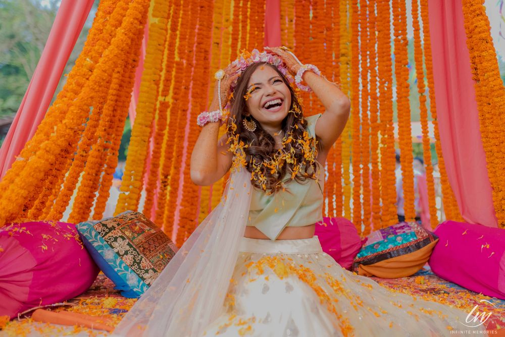 Photo of A bride in a pastel lehenga and tiara for her mehndi