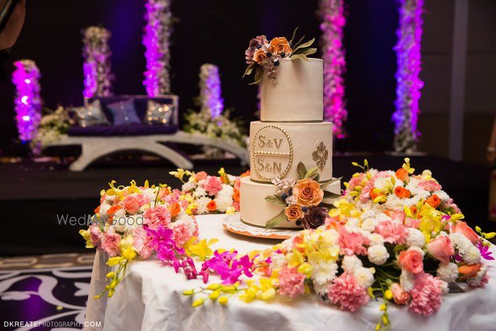 Photo of white wedding cake indian with pink flowers