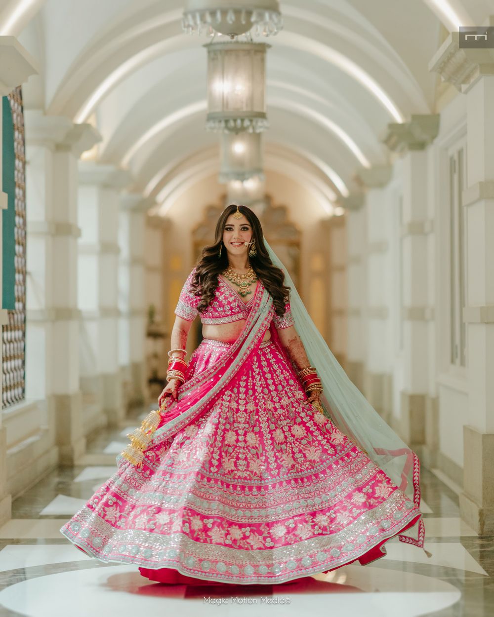Photo of Bride twirling in a pink lehenga