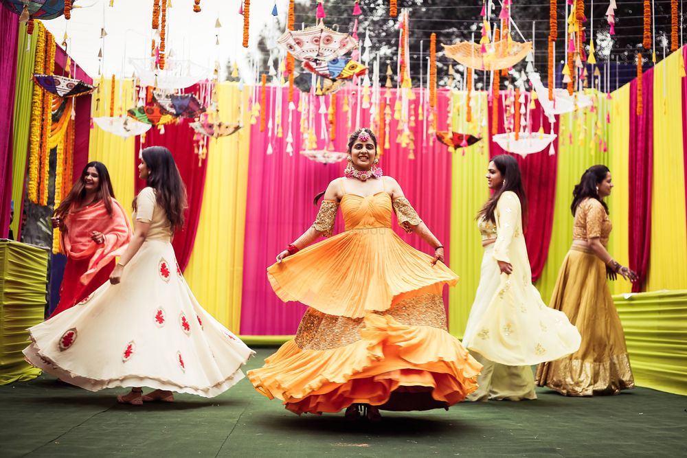 Photo of dancing bride with bridesmaids on her mehendi