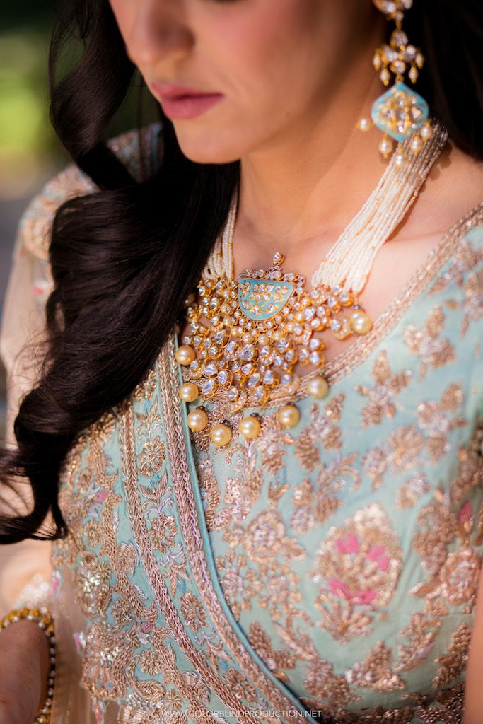 Photo of Shot of a bride in powder blue lehenga wearing golden and white beads necklace.