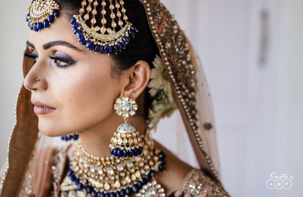 Photo of Bride in an exquisite polki jewellery with blue beads.