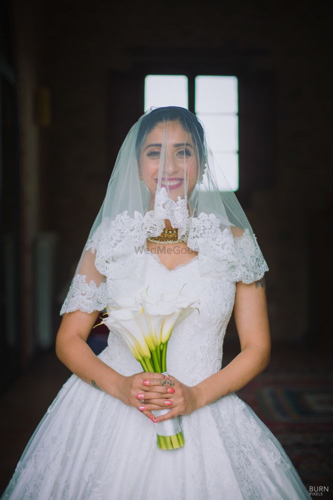 Photo of Bride with lace veil and bridal bouquet