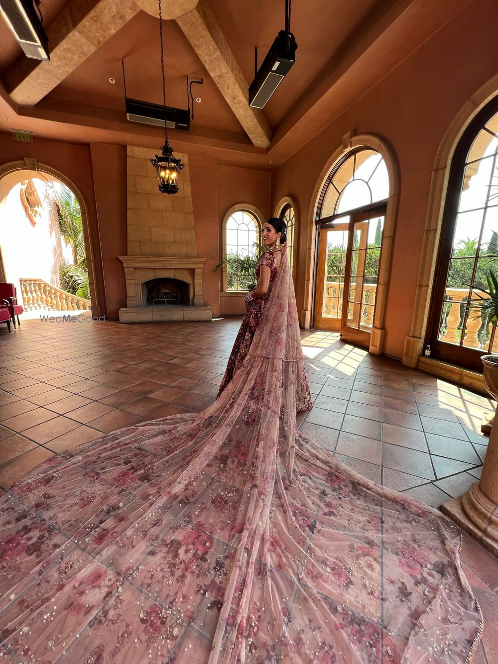 Photo of bride in maroon lehenga with light pink contrasting dupatta as a long train