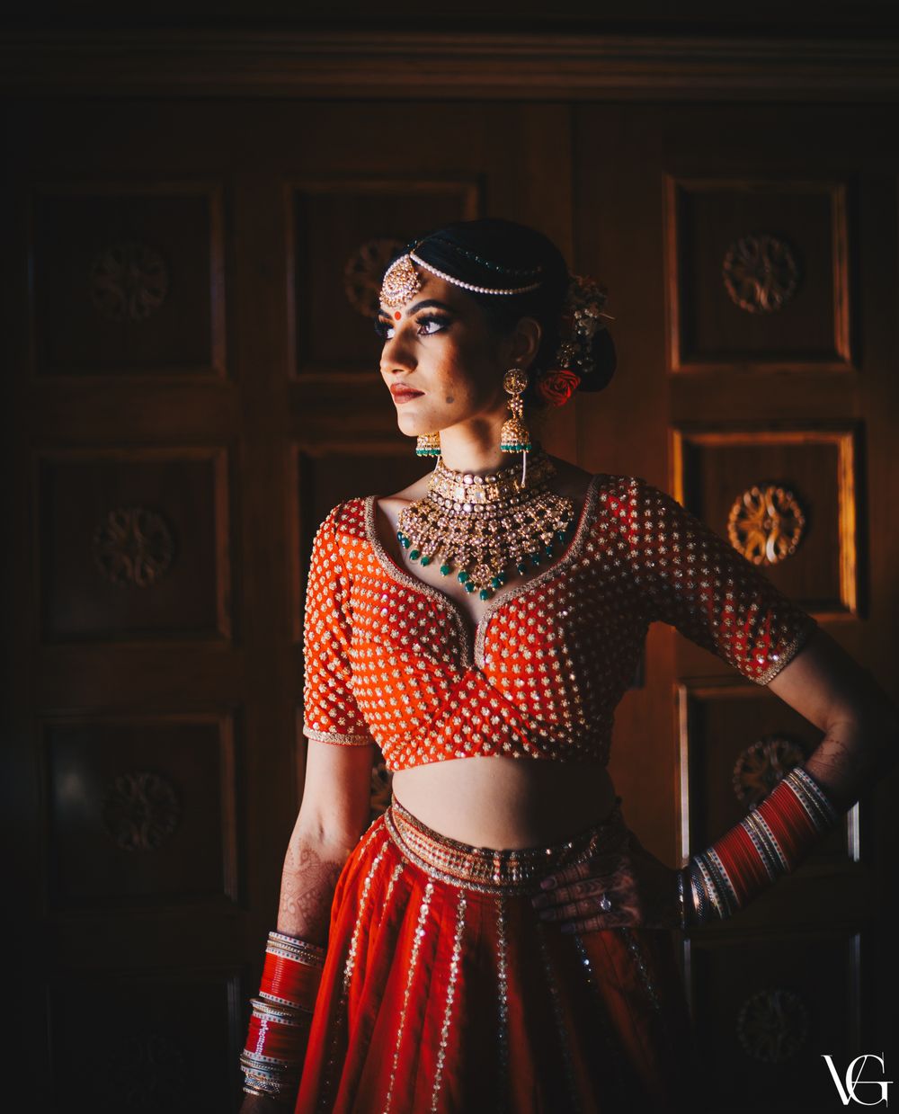 Photo of Bride getting ready shot wearing a red choli cut blouse