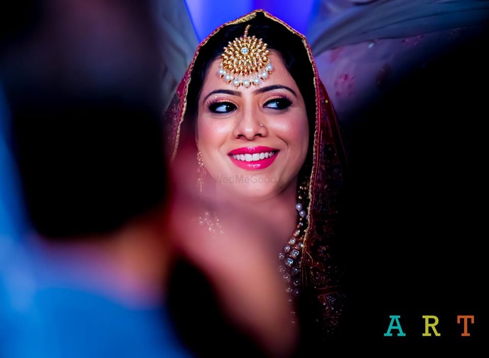 Photo of Smiling Bride Wearing Gold Maangtikka
