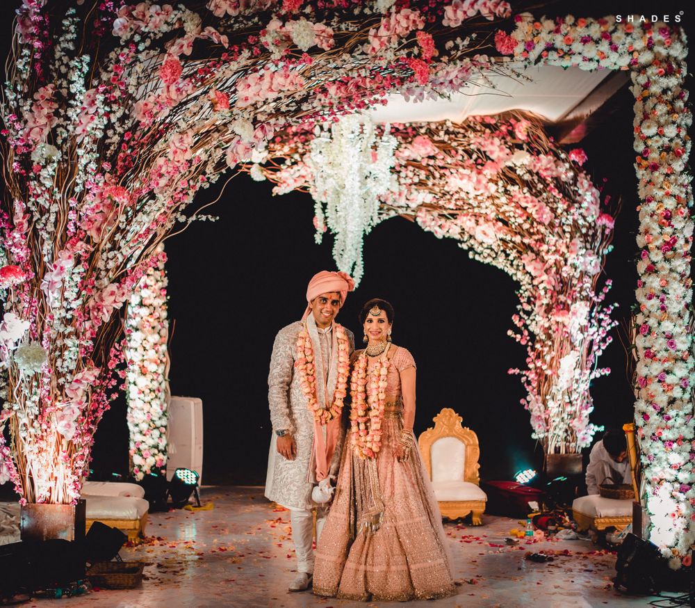 Photo of A couple poses at their unique floral mandap