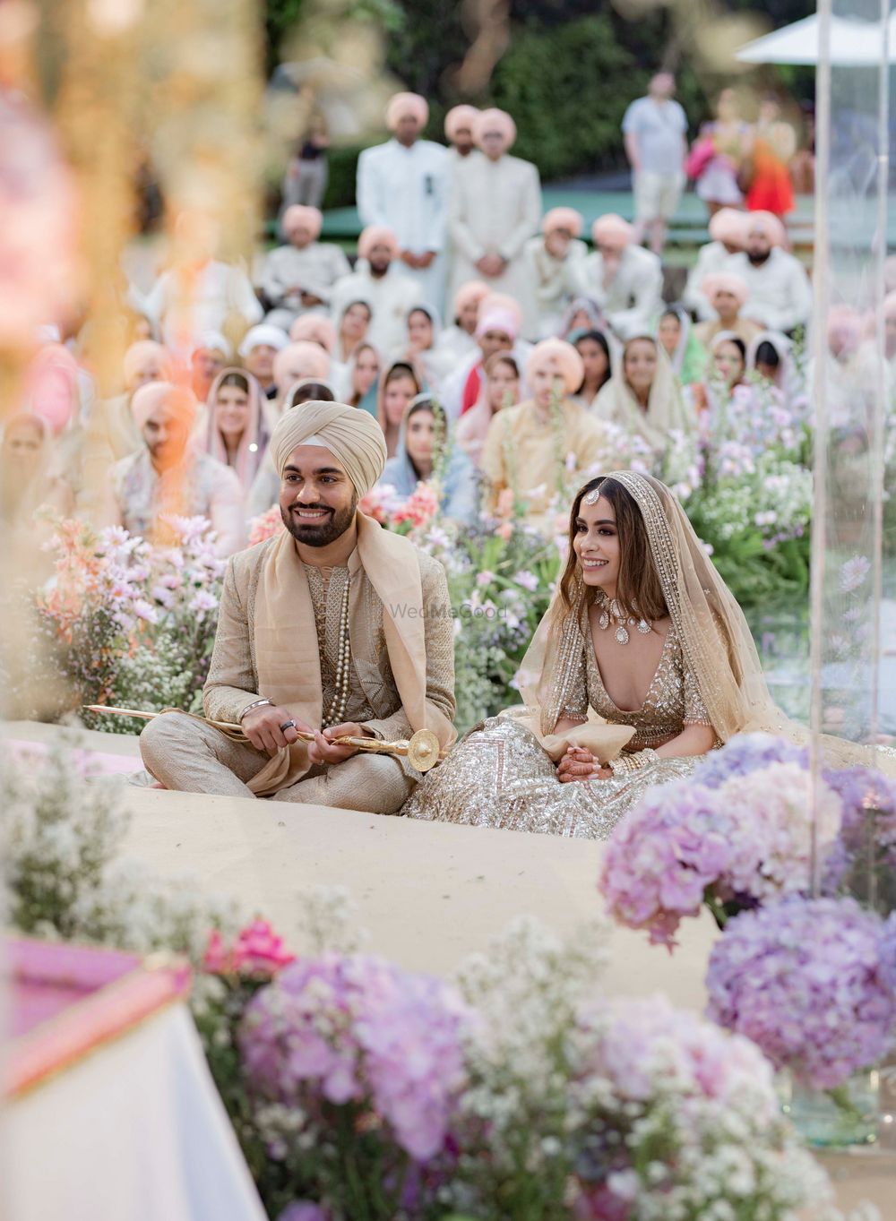 Photo of smiling couple in gold-toned coordinating outfits at anand karaj