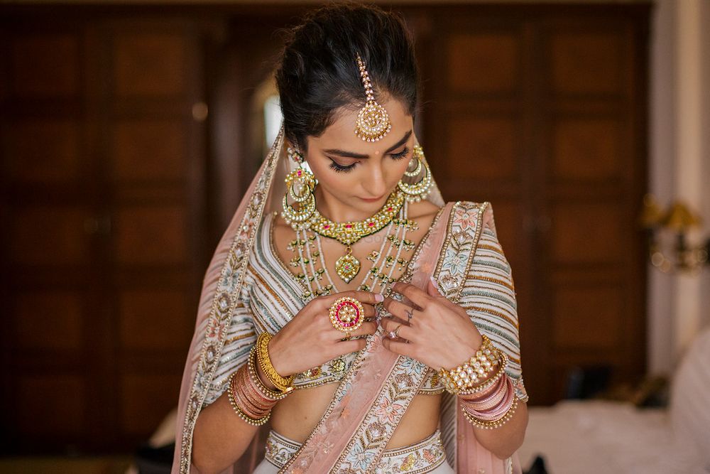 Photo of Bride wearing jewellery and fixing it