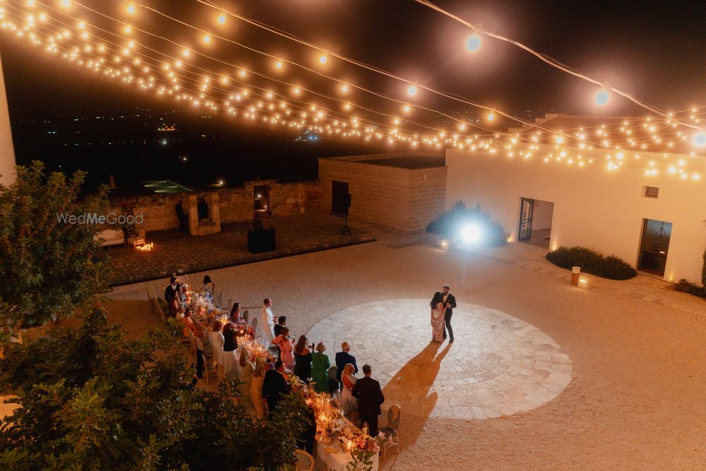 Photo of Lovely shot of the bride and groom dancing under a canopy of lights at an outdoor reception