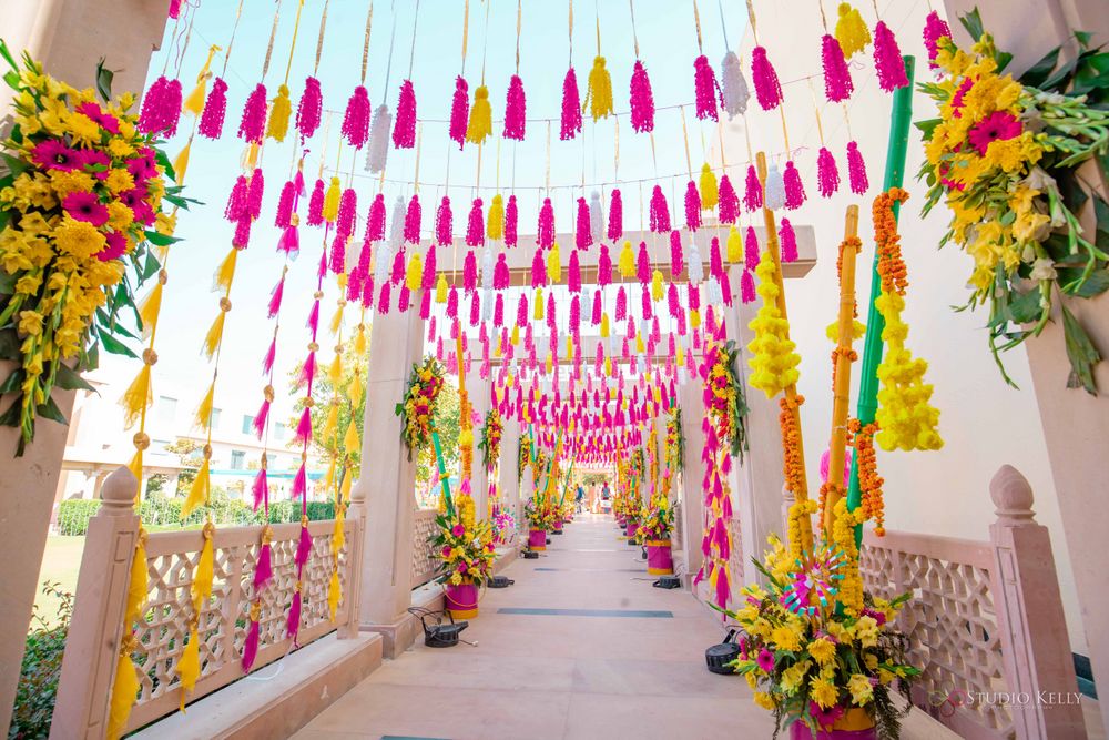 Photo of mehendi entrance decor idea with tassels and florals