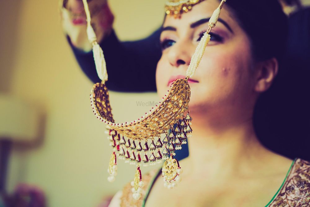 Photo of bride trying on necklace