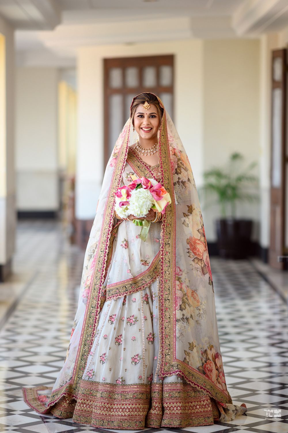 Photo of Bride in a beautiful white and pink floral lehenga