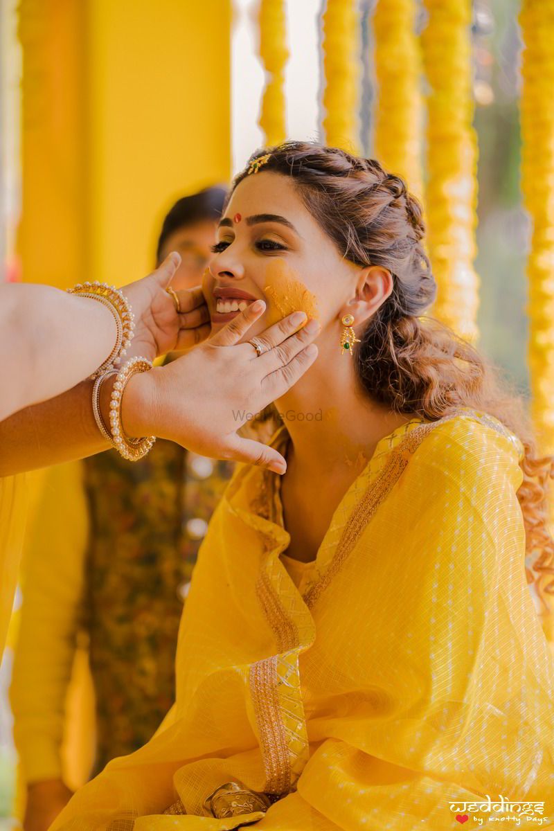 Photo of Bridal haldi portrait with people putting colour on her