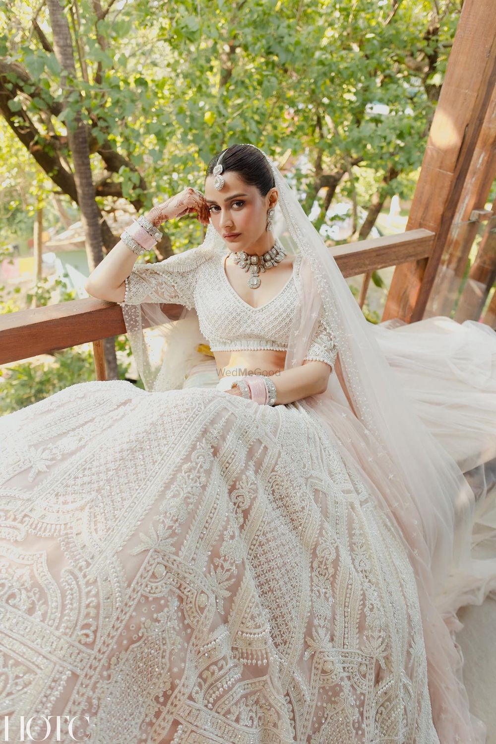 Photo of This timeless bridal portrait in an all-white lehenga with a light pink chooda.