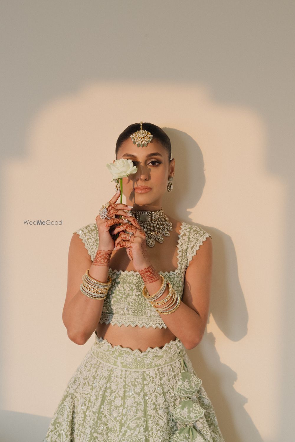 Photo of Bridal photoshoot idea with flower with a bride wearing an offbeat lehenga
