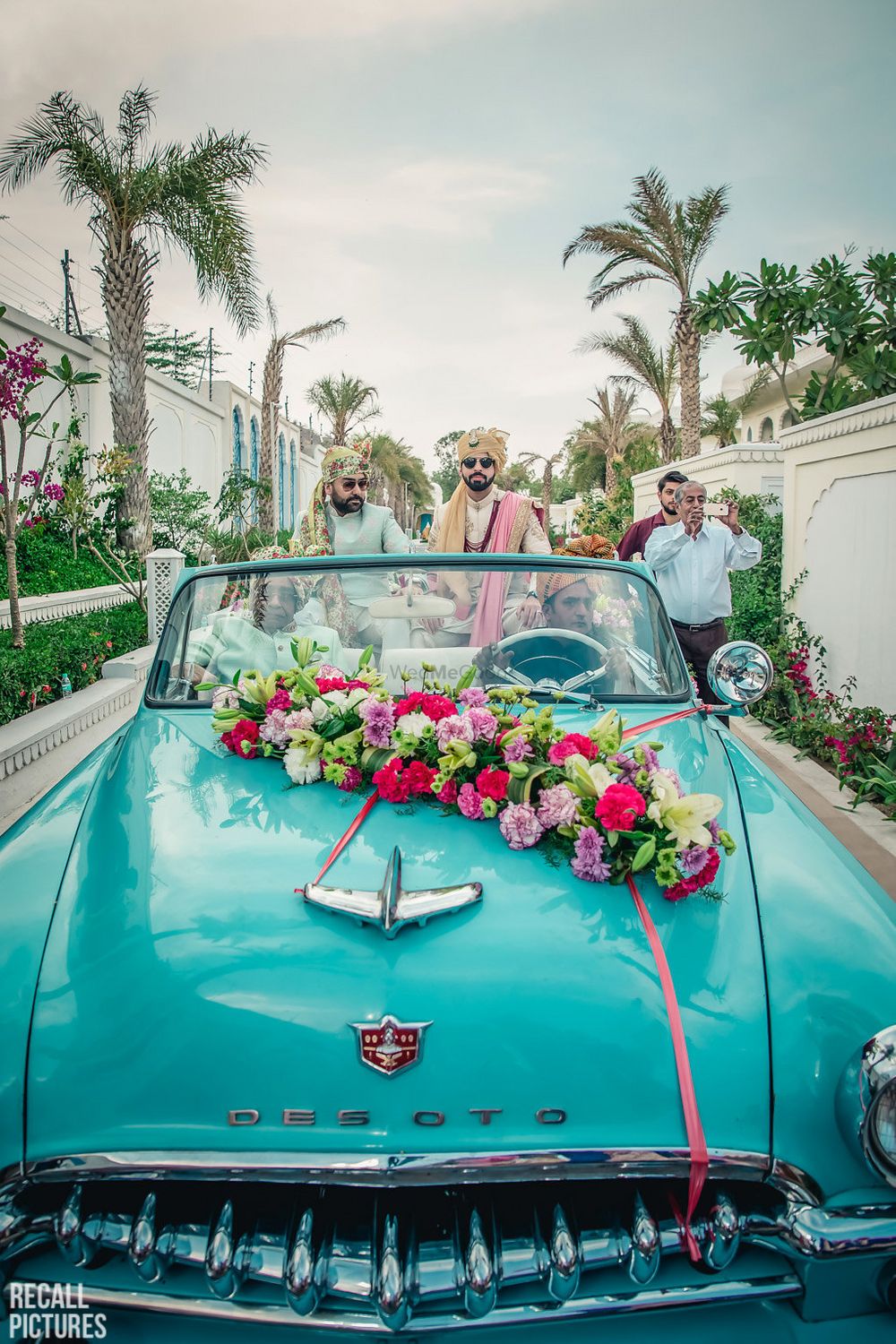 Photo of Groom entry idea in a blue vintage car