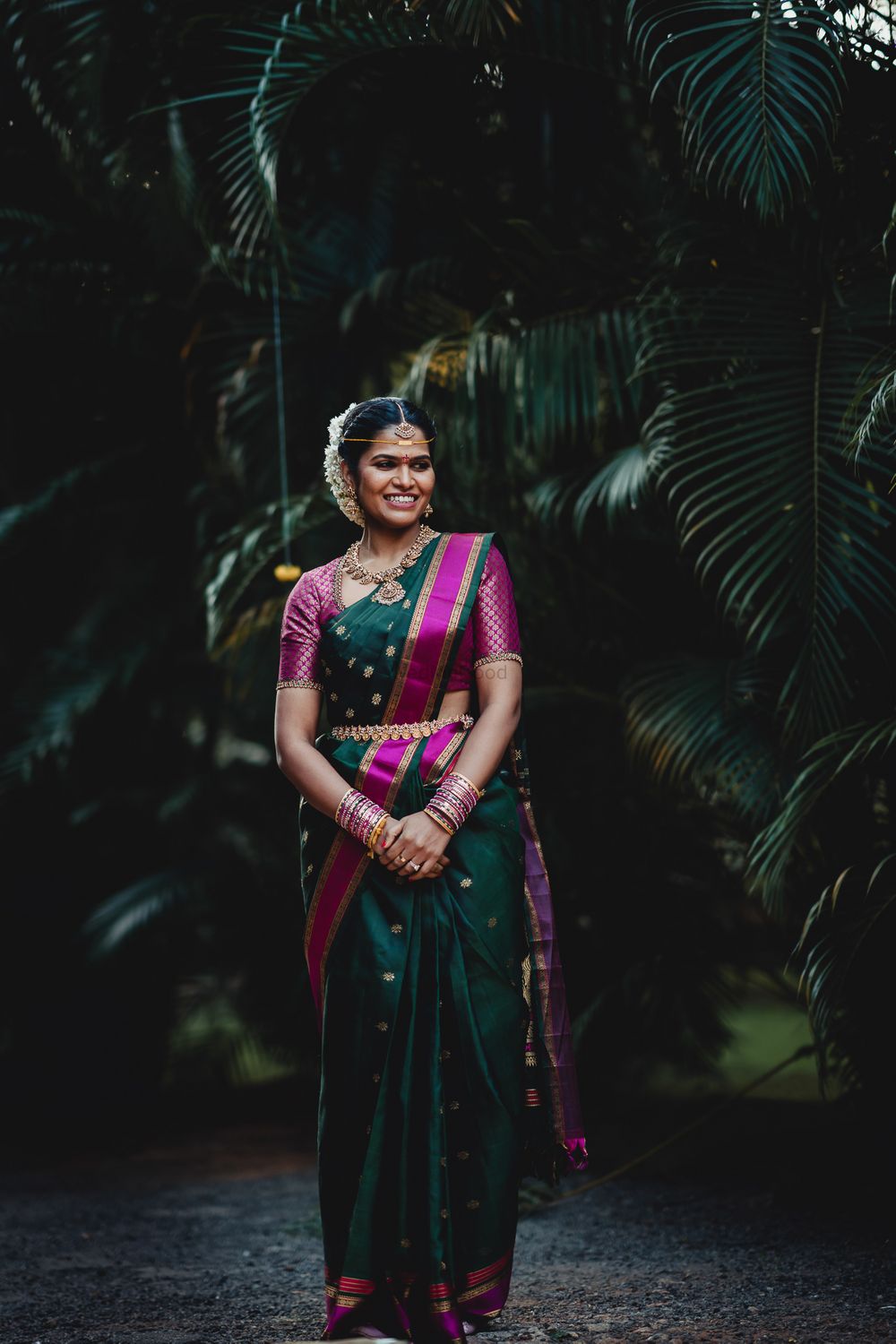 Photo of South indian bride wearing a dark green and purple kanjivaram saree on her wedding