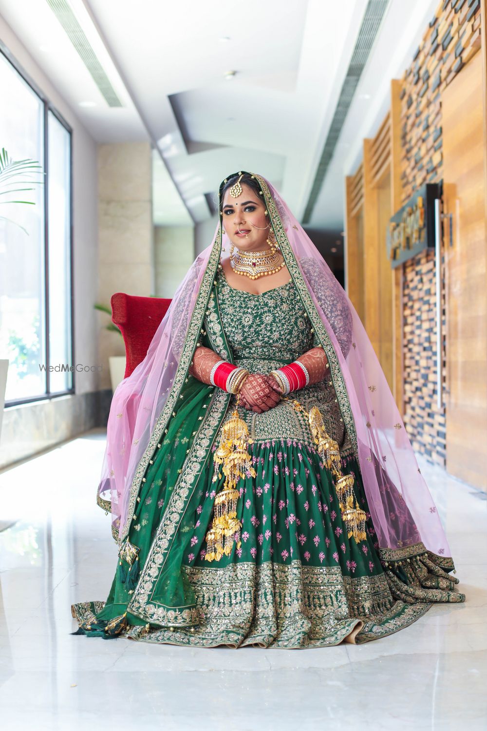 Photo of bride in a dark green anarkali with pink dupatta