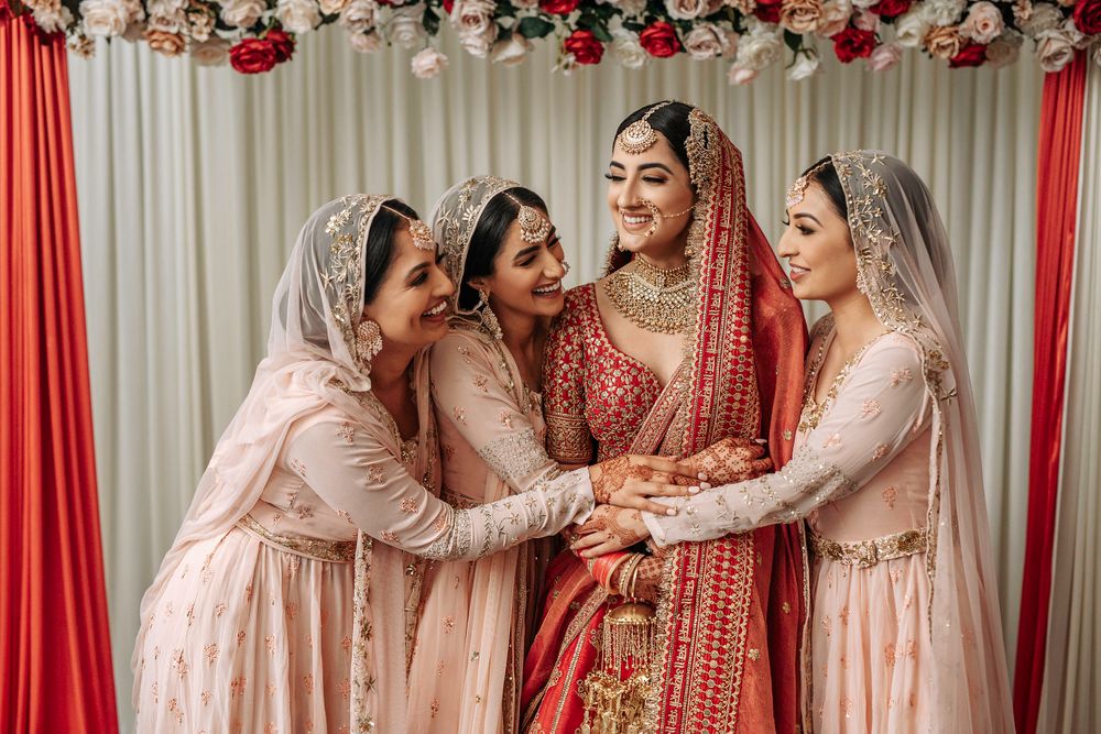 Photo of Bride posing with colour-coordinated bridesmaids