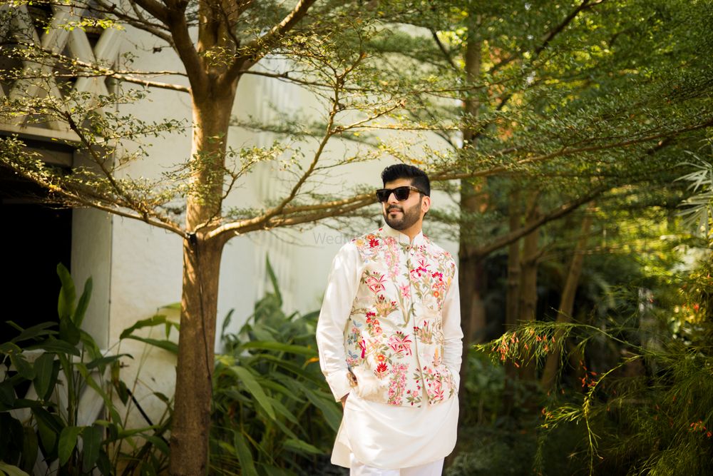 Photo of Groom in a floral print nehru jacket and white kurta pajama for the Mehndi