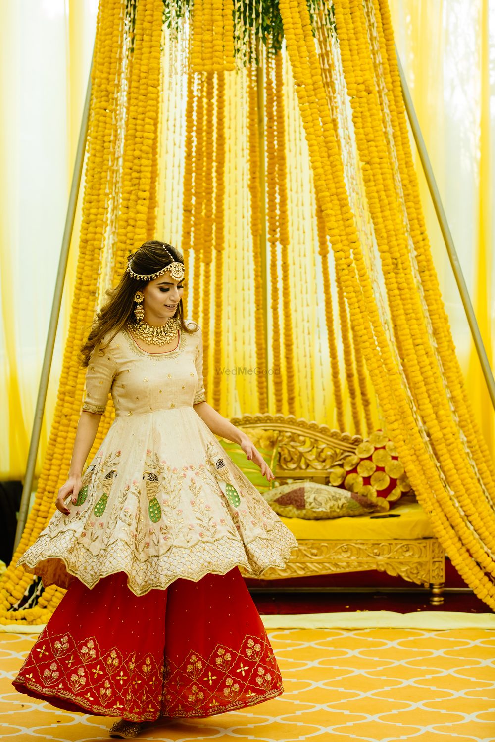 Photo of A bride in a unique outfit, twirling on her mehndi day