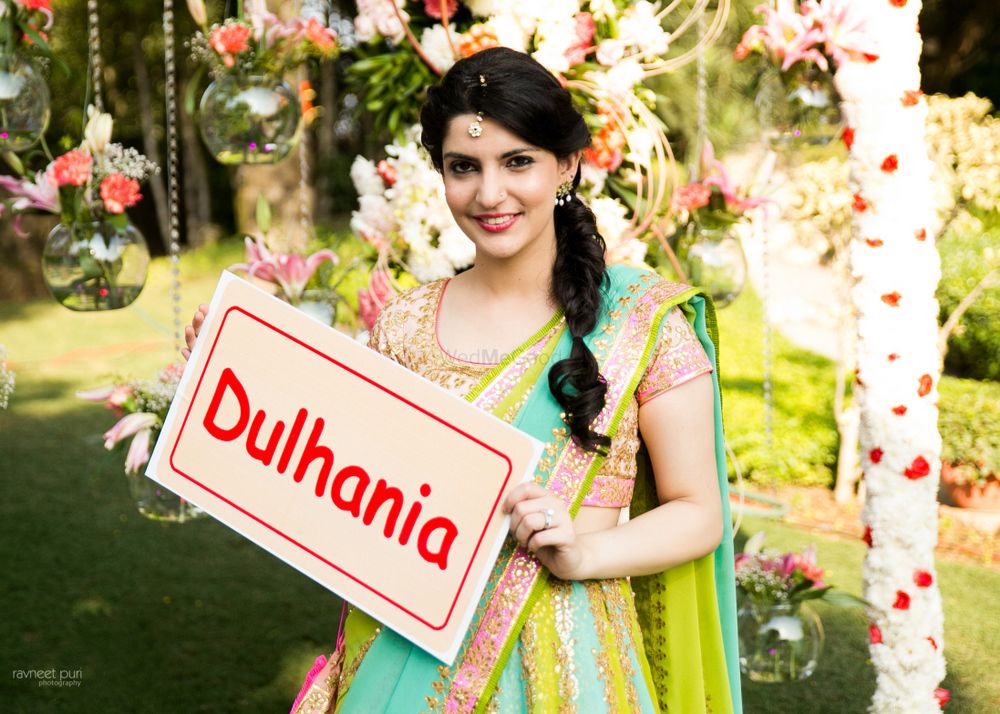 Photo of Bride holding dulhania tag in aqua and green