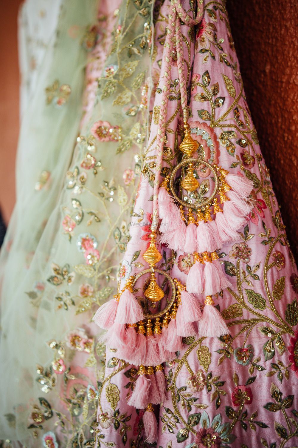 Photo of Unique light pink bridal lehenga tassels