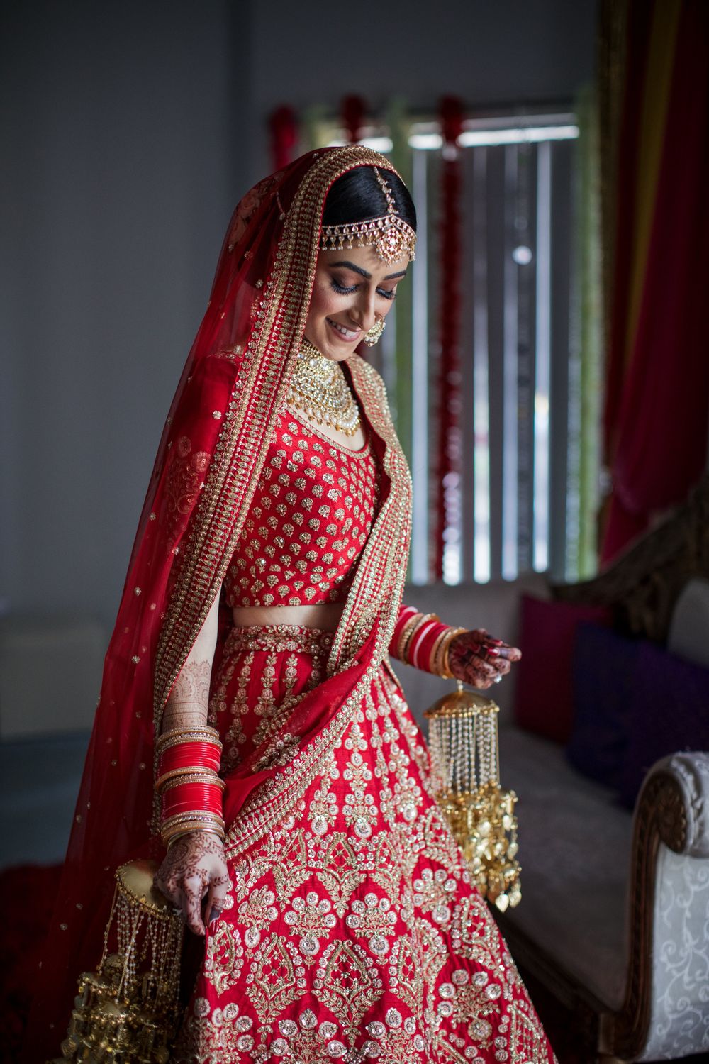 Photo of A bridal portrait on wedding day with the bride in a red Sabyasachi lehenga
