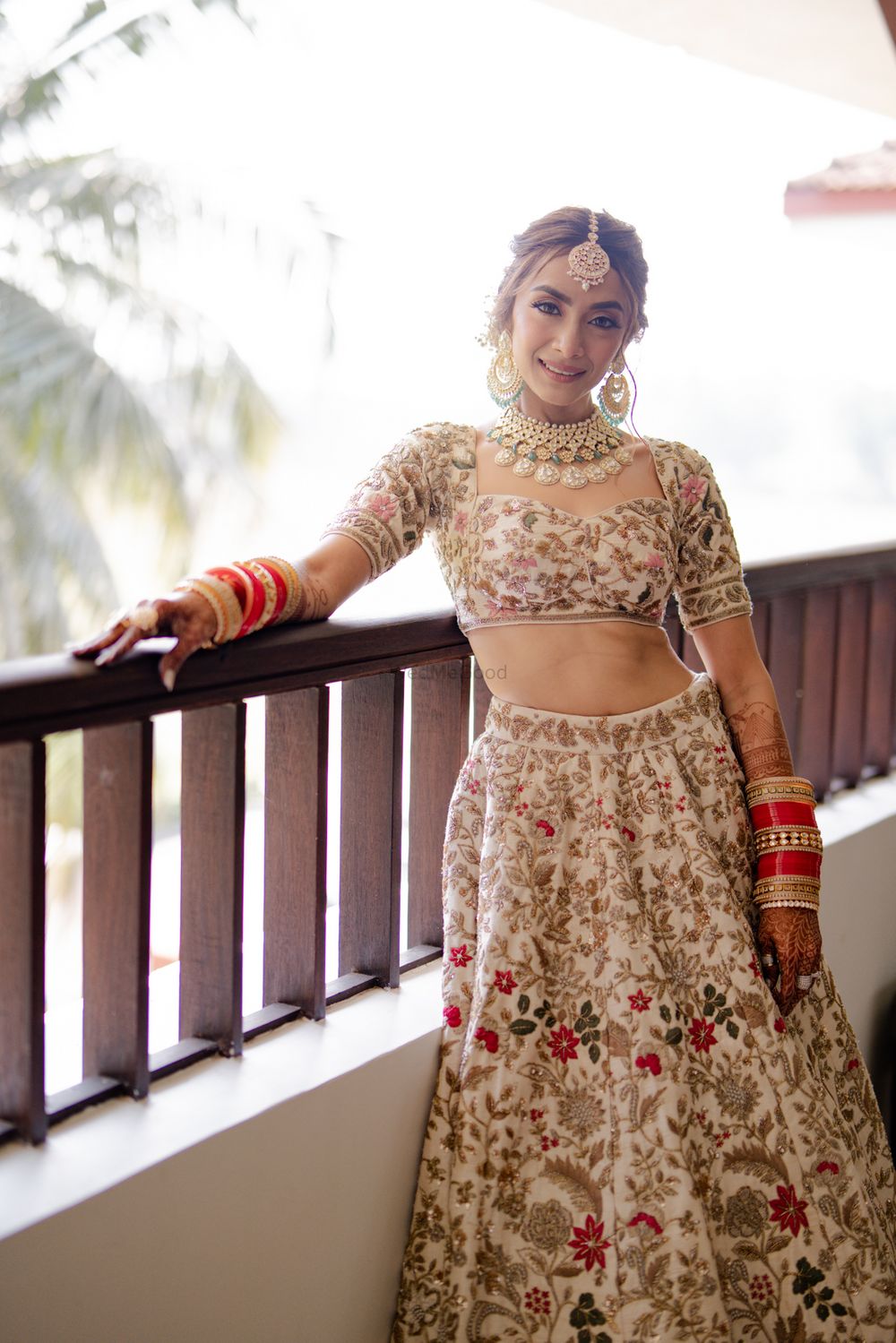 Photo of Gorgeous bridal portrait with the bride donning an ivory lehenga with floral work all over