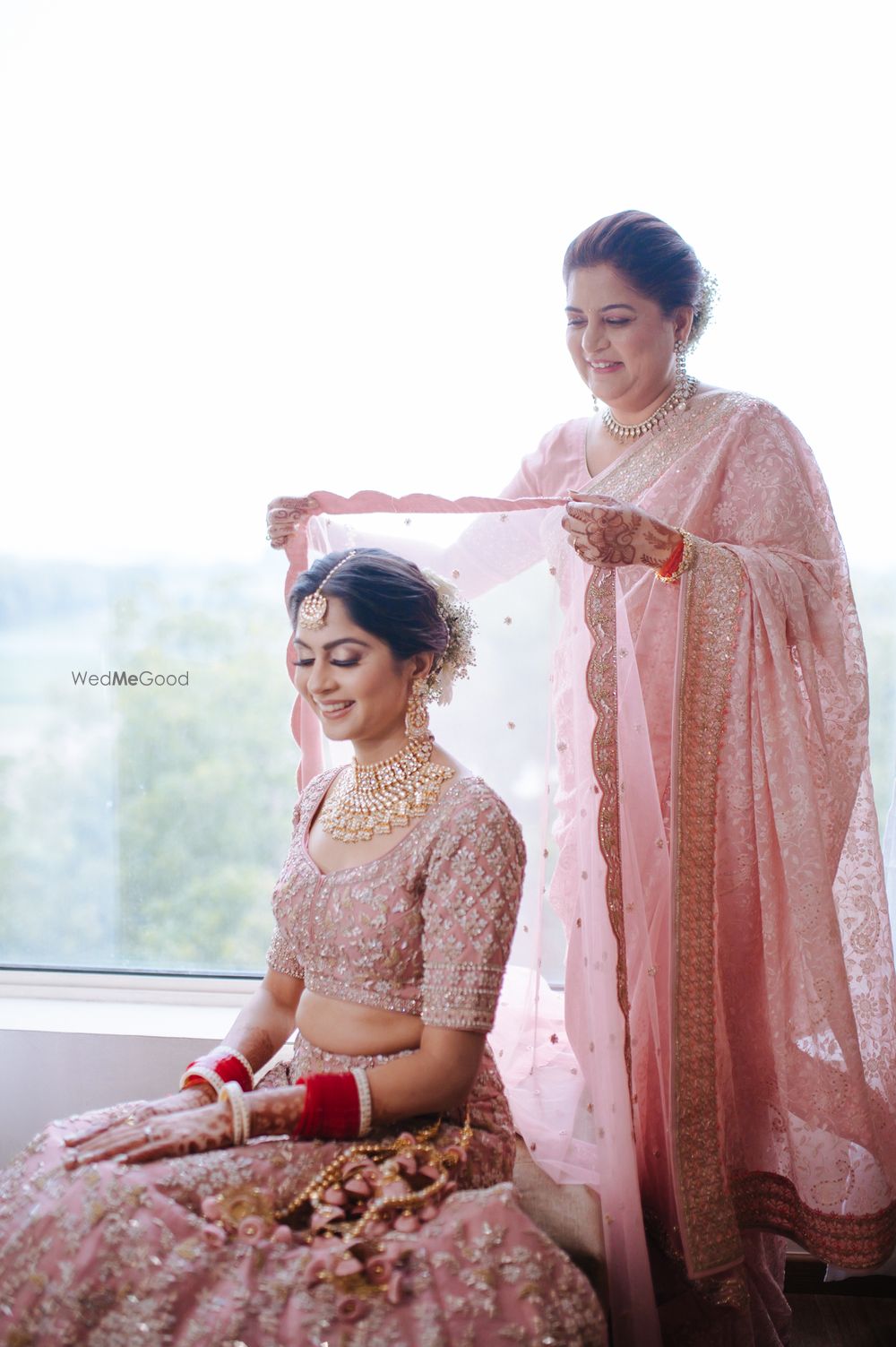 Photo of Candid shot of a mother placing her daughter's dupatta.