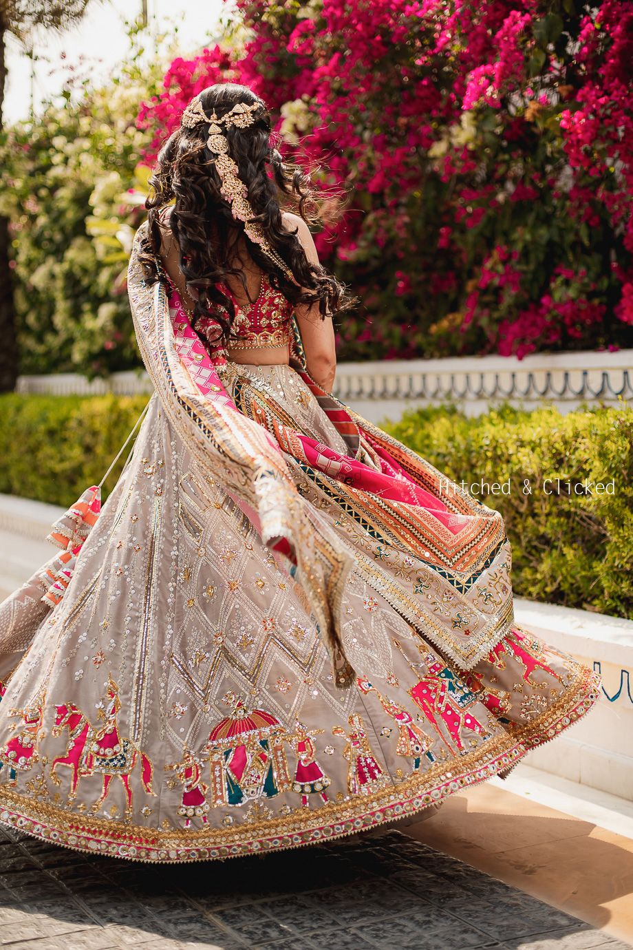 Photo of bride in a grey lehenga twirling with open hair with jewellery