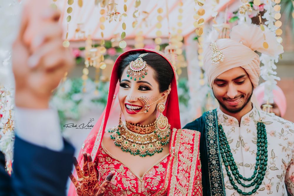 Photo of happy bride shot in green jewellery and red lehenga