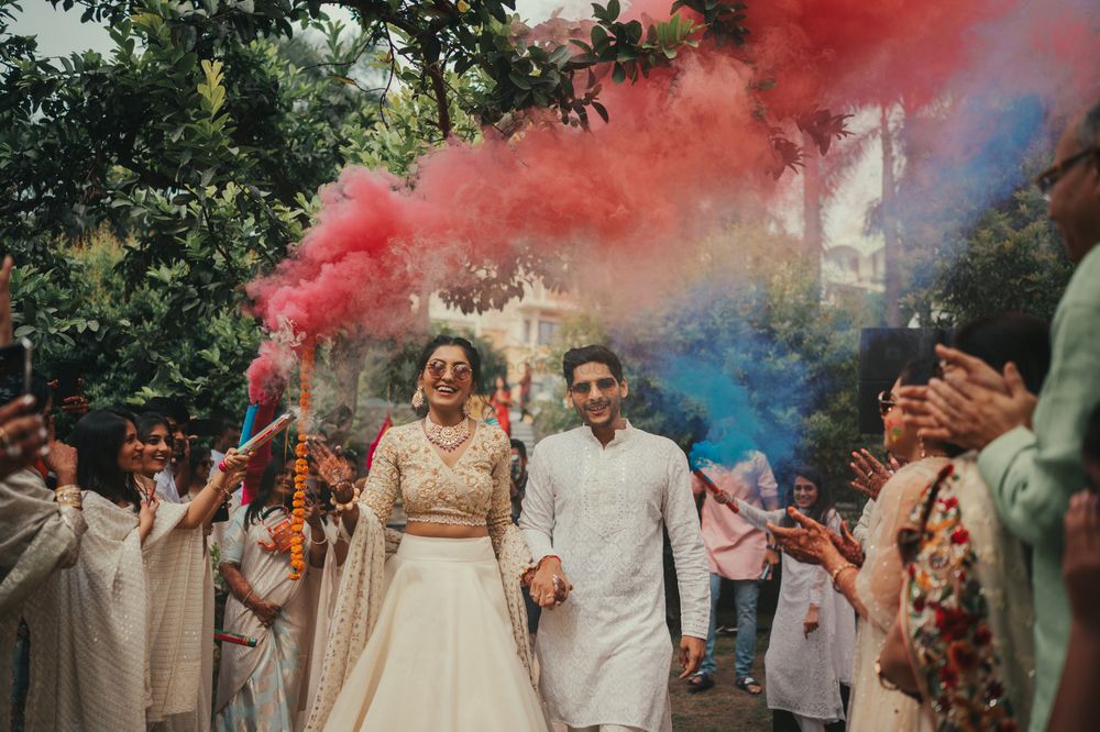 Photo of A fun couple entry on the holi function with smoke bombs