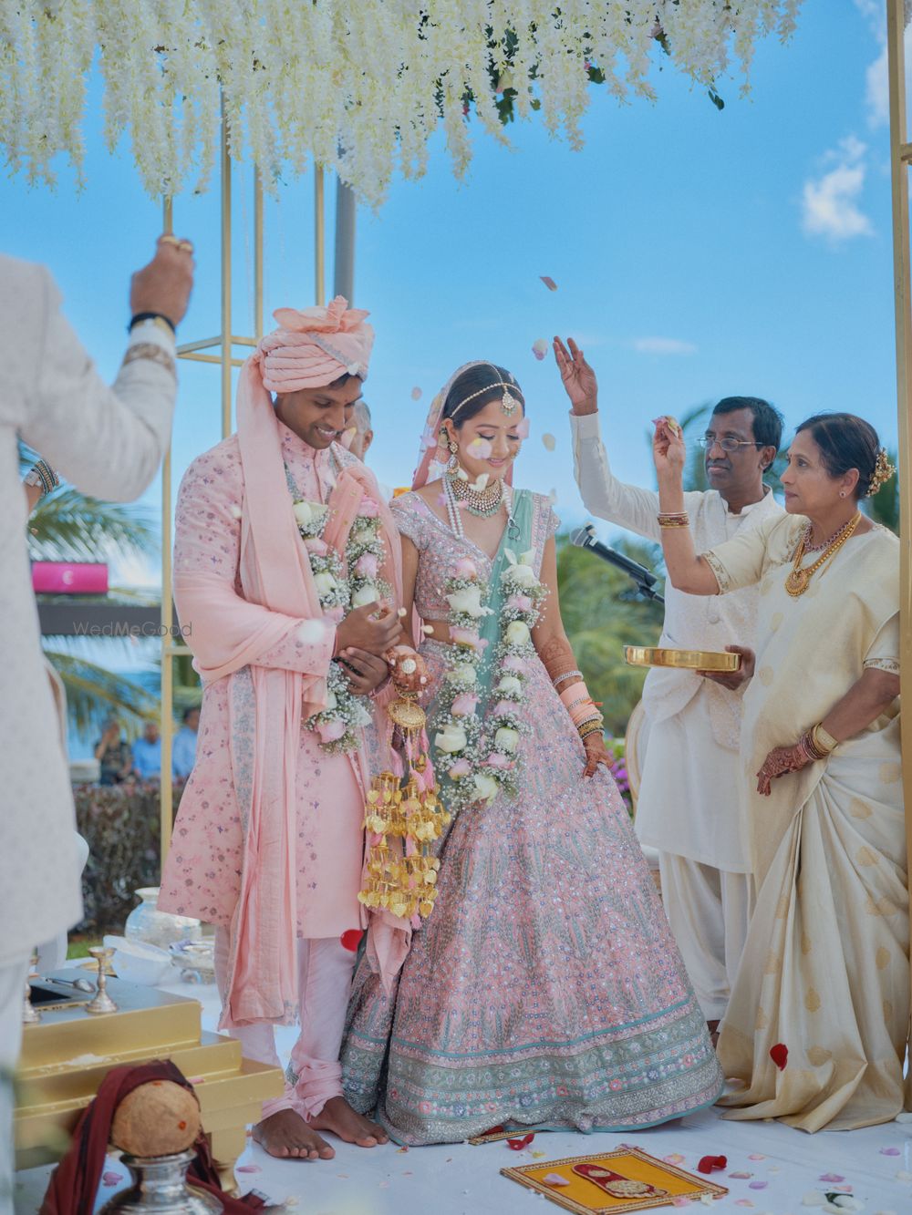 Photo of happy post wedding shot with the bride and groom wearing matching pink