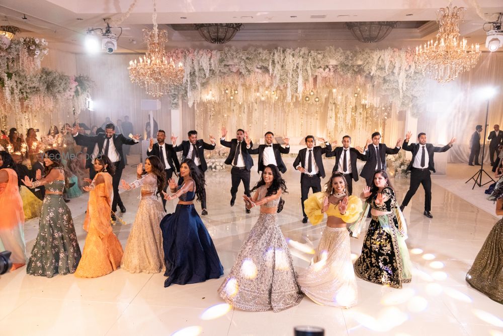 Photo of Bride with bridesmaids and groomsmen dancing on the sangeet