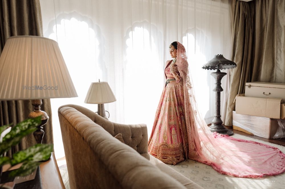Photo of Classic bridal portrait on the wedding day with the bride in a light pink lehenga and a belted dupatta drape