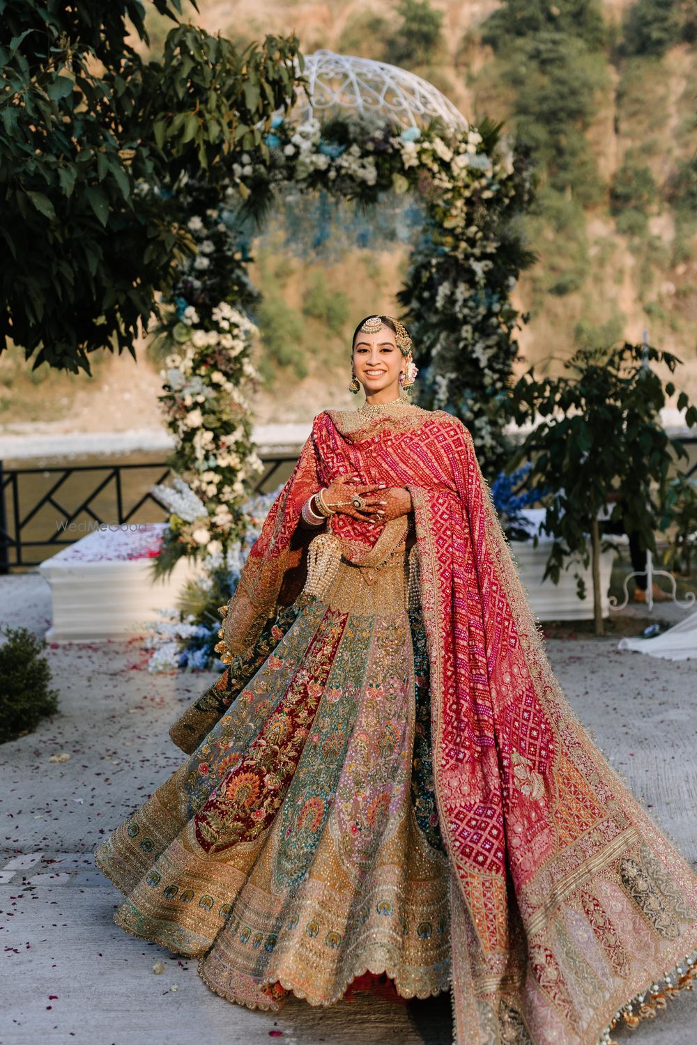 Photo of Stunning multi-coloured panelled bridal lehenga with an embroidered red dupatta