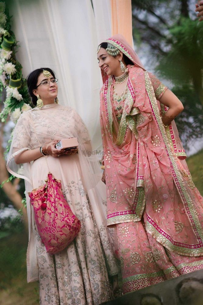 Photo of Sikh bride in pastel pink sharar with bridesmaid