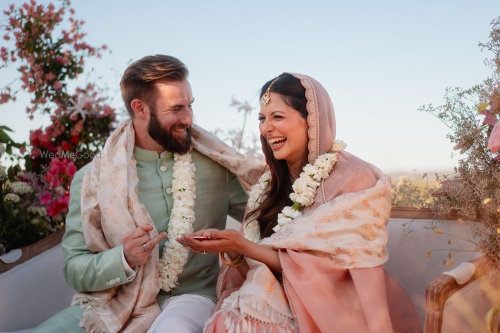 Photo of Happy candid capture of teh bride and groom on the wedding day