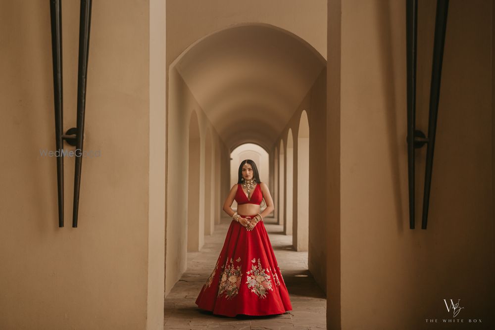Photo of Classic bridal portrait with the bride in an all-red lehenga look, plunge neck blouse and statement jewellery